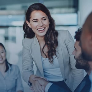 A woman giving a handshake to her colleague