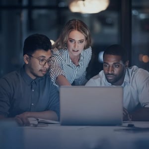 A team of 3 looking at a laptop together