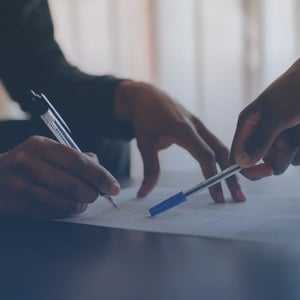 Two people going over a document pointing with pens